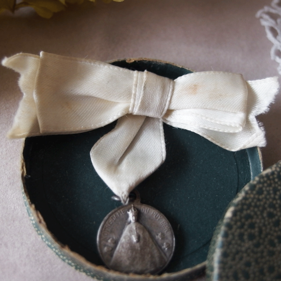ノートルダム・ド・フランス 白いリボンとメダイのブローチ（紙製ケース付き）