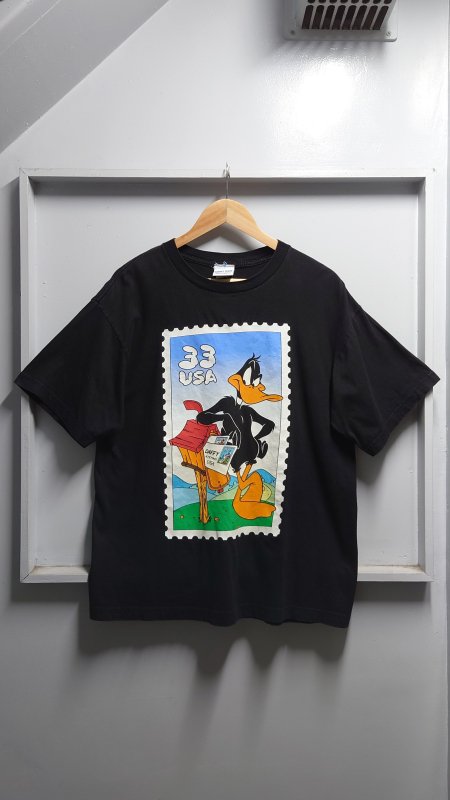 <img class='new_mark_img1' src='https://img.shop-pro.jp/img/new/icons5.gif' style='border:none;display:inline;margin:0px;padding:0px;width:auto;' />90’s LOONEY TUNES “Stamp Collection” ダフィーダック プリント Tシャツ ブラック L 半袖 ルーニーテューンズ (VINTAGE)