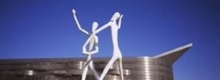 Panoramic Images  Dancers sculpture by Jonathan Borofsky in front of a building 