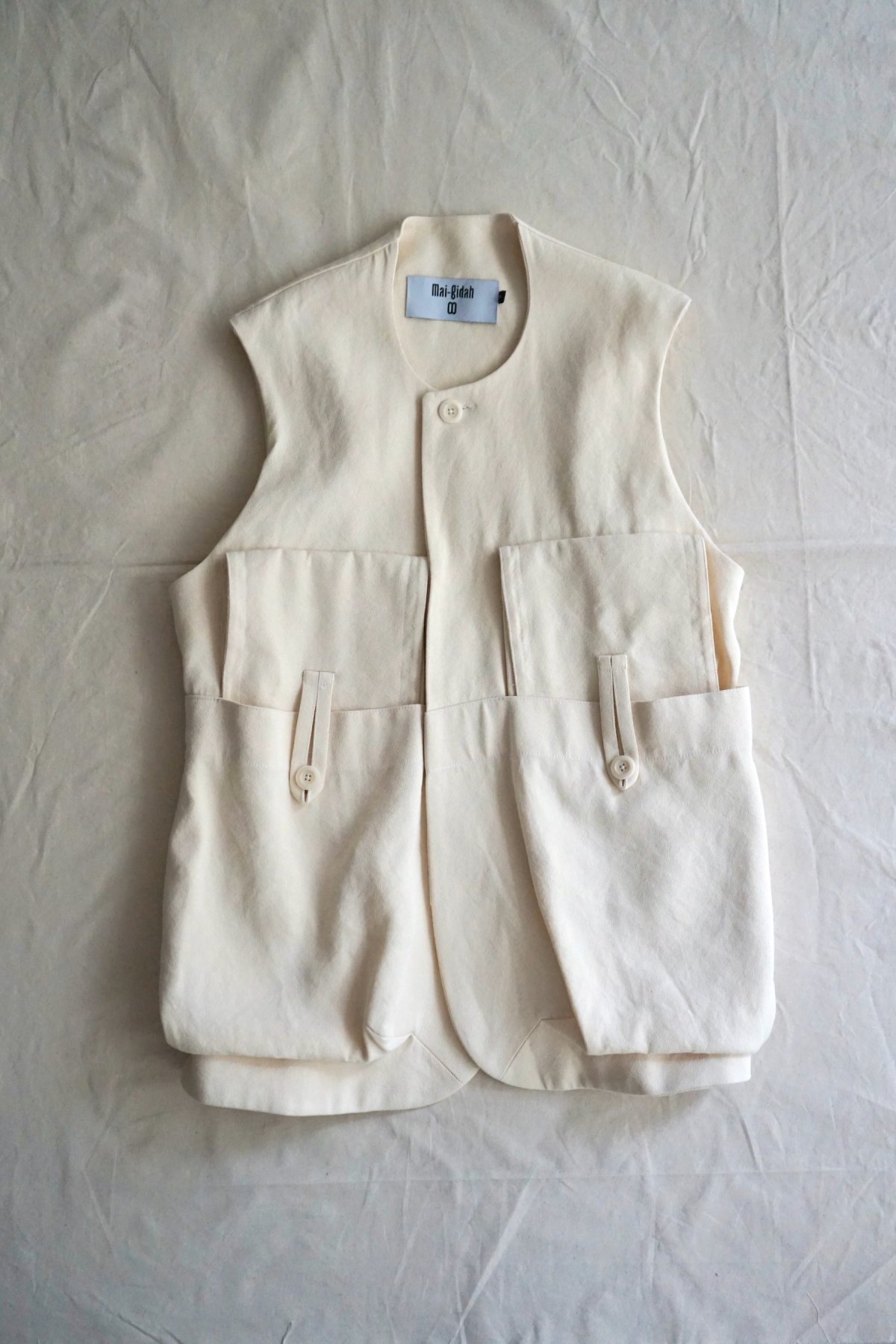 MAI GIDAH / Sleeveless Jacket with a-symmetrical balloon-pockets and belt / Cream