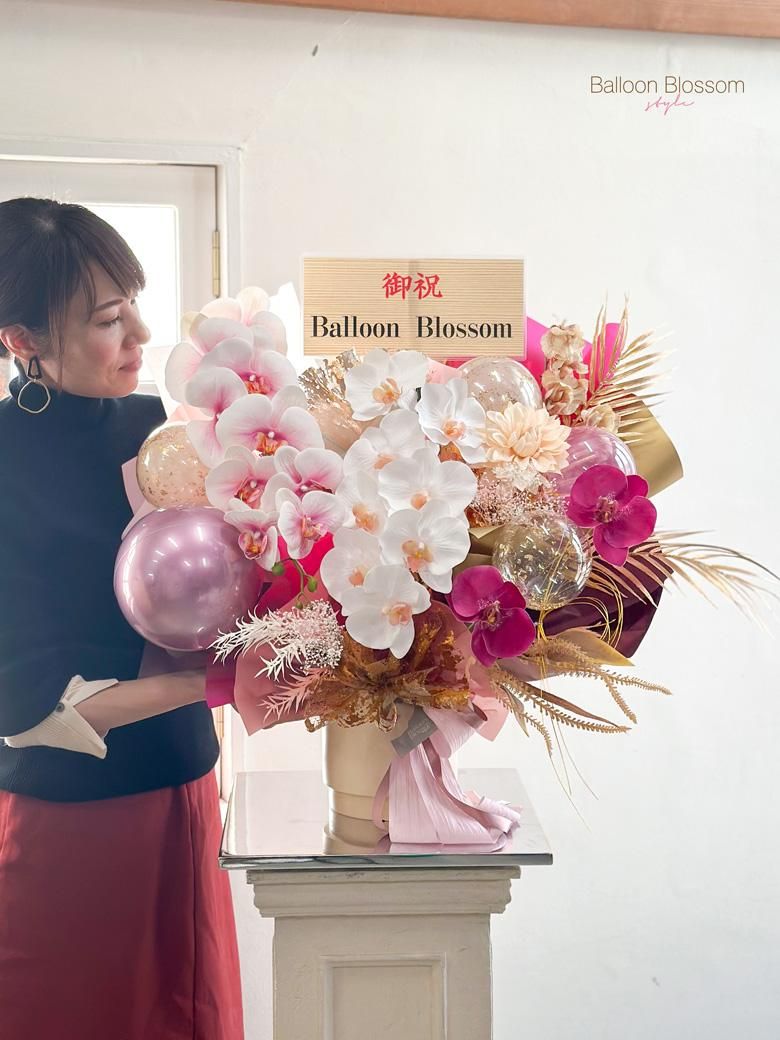 上品で美しい胡蝶蘭アレンジメントの隣に人が立った時の様子