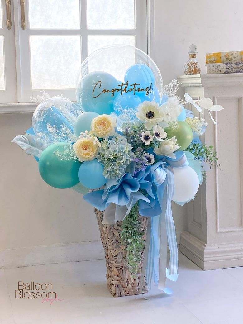 アイスブルーのクリアなバルーンと豪華なお花の組み合わせアレンジメントを飾った様子